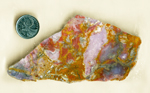 Purple, red and violet patches among golden-orange mossy inclusions in a slab of Purple Swirl Agate from Mexico.