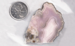 Pink Parcelas Agate with a central pale fortification and ghostly spheroids.
