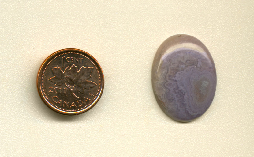 Calibrated oval polished Royal Aztec Agate cabochon, with purple lace patterns covering its surface.