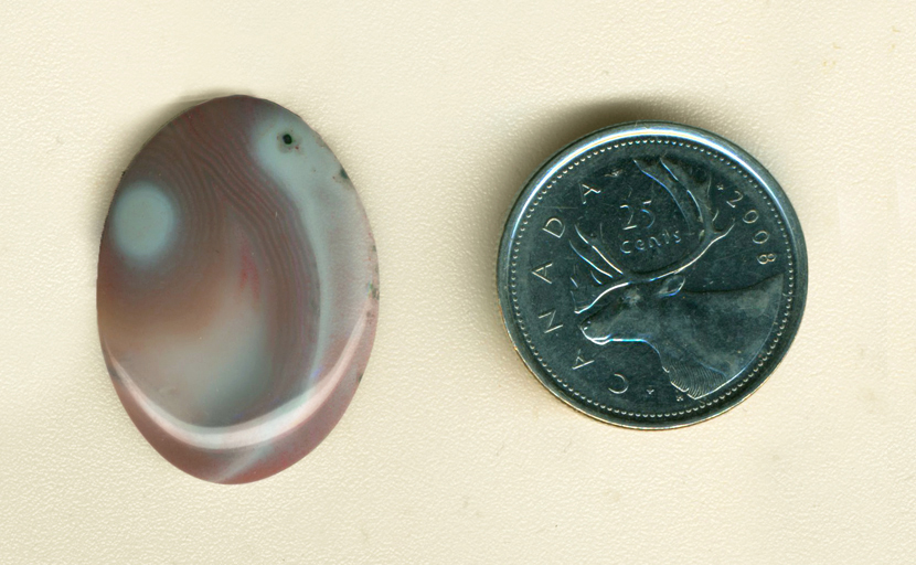 Botswana Agate cabochon from Africa, with purple, blue and pink patterns based around white shapes.