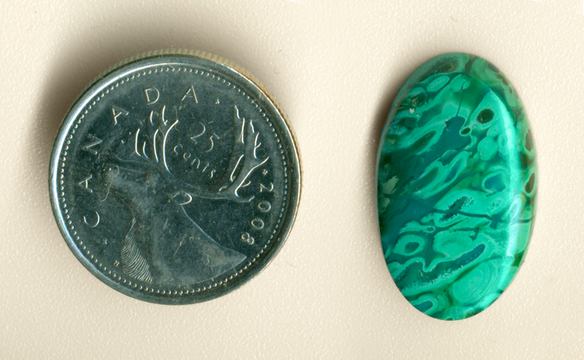 Bright green Malachite tubes in a Gem Silica base, forming a cabochon of Malachite in Gem Silica, from the Inspiration Mine, Globe County, Arizona.