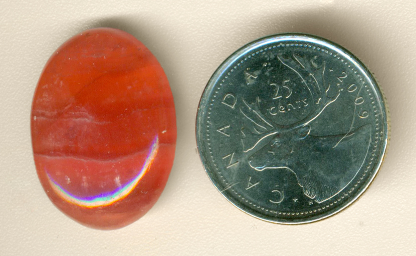 Bright pink banded cabochon of Rhodochrosite from Argentina.