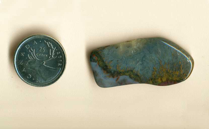 Mexican Sagenite Lace Agate, with orange streaks going up into a blue-gray background, and red marks beneath them.