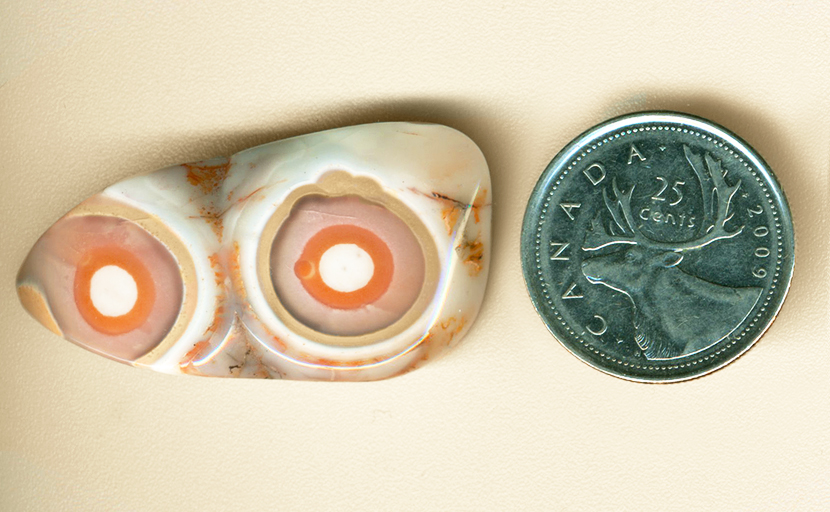 Two eye patterns, of orange, pinkish-purple and yellow, in a freeform Structural Eye Agate.