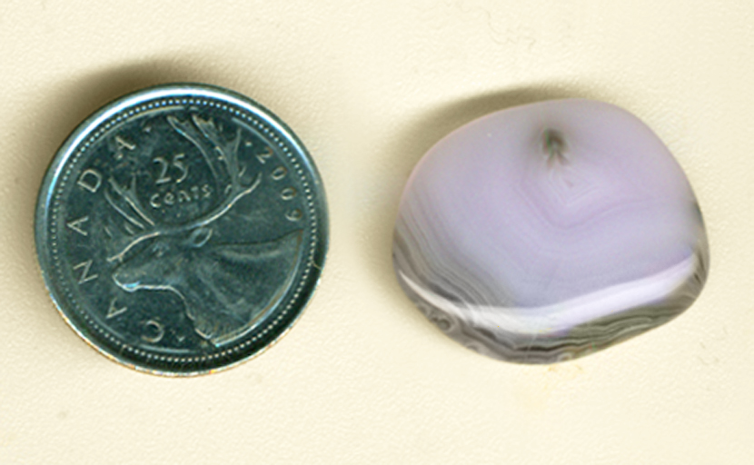 Purple, pink and gray concentric lines in a freeform cabochon of Parcelas Agate from Mexico.