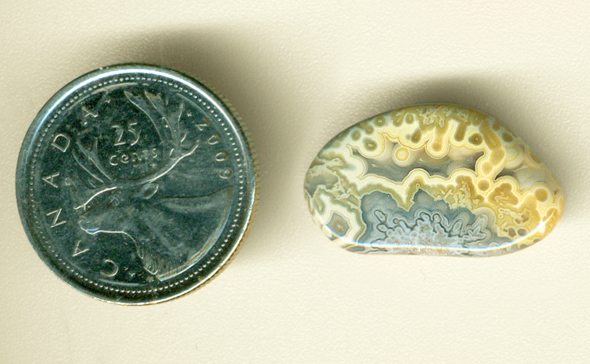 Blue explosion pattern at the bottom of two layers of yellow tubes in a freeform polished Crazy Lace Agate from Mexico.