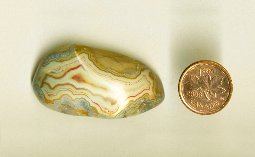 A freeform Fairburn Agate from Nebraska or South Dakota, with blue flower patterns surrounding a fortification pattern of red and yellow.