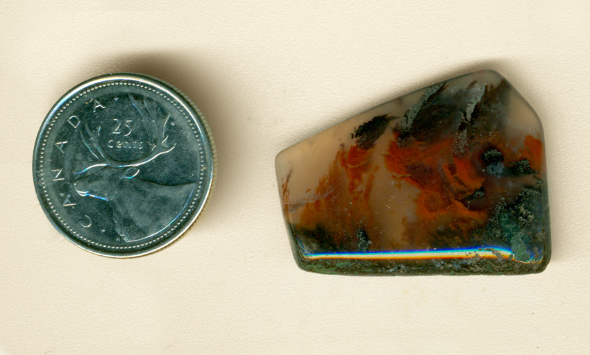 Freeform polished Mexican Flame Agate cabochon, with a black and green ground, red flames, and black smoke up above, all trapped in clear agate.