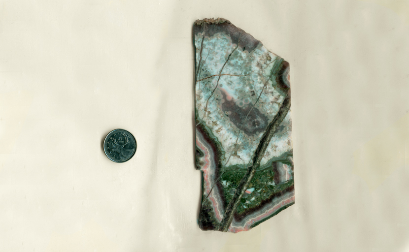 A slab of Mexican Amethyst Lace Agate, with pink, green, blue and purple stripes and bubbles. Occasionally, there are shards of stripes in among the other areas. 