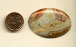 Calibrated polished Fairburn Agate cabochon from Nebraska of South Dakota, creamy and with reddish brown concentric patterns.