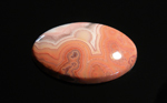 Freeform polished Fairburn Agate cabochon, orange and pink patterns of swirls and orbs.
