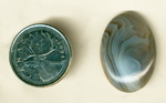 Calibrated oval polished Botswana Agate cabochon, with swirls of blue and gray folded over on themselves.