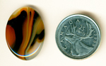 Orange, black, yellow and clear patterned cabochon of Montana Agate.