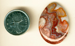 Layered step-patterns of pink, red, yellow and orange lace in a teardrop-shaped polished piece of Crazy Lace Agate from Mexico.