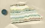 A slab of Dogtooth Lace Agate from Mexico, with pink, yellow and blue zigzag, lace and wavy patterns in parallel lines.