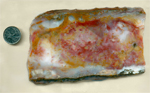 A slab of Vaquilla Agate from Mexico, with a veil of red and yellow colors on a pale blue background.