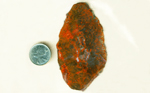 Orange, red and white storms across a gray surface in a slab of Agate Pseudomorph After Barite.